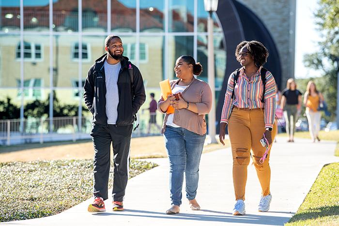 Three TCU students walk together on campus